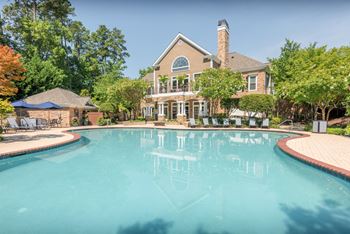 a high-end swimming pool with a clubhouse behind it at Lex at Brier Creek in Morrisville, North Carolina